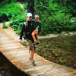 Chris Taylor and LittleMan crossing suspension bridge Glacier National Park