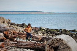 LittleMan walking on driftwood at Point Wilson Lighthouse Fort Worden Port Townsend 3