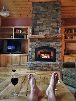 Rob Taylor feet and wine with stone fireplace in John Muir House at Evergreen Lodge at Yosemite National Park 1