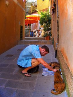 Chris Taylor petting cats in Cinque Terre Italy