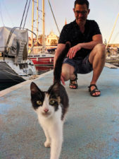 Chris Taylor petting cat in port at Milna Brac Croatia 1