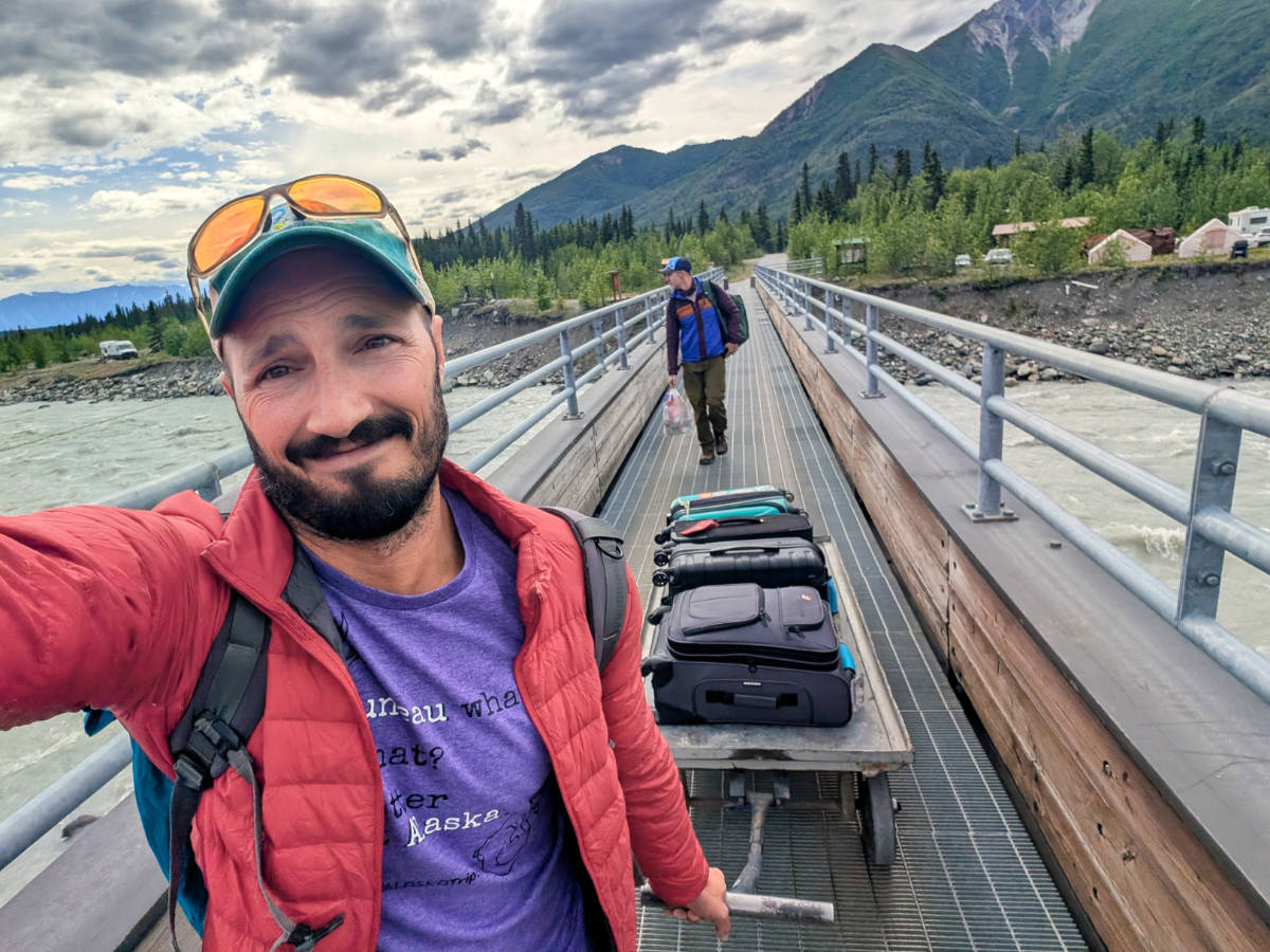 Rob Taylor pulling luggage across Kennicott River Footbridge to McCarthy Alaska