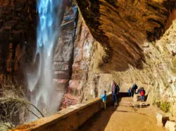 Taylor Family behind waterfall at Weeping Wall trail Zion National Park Utah 3