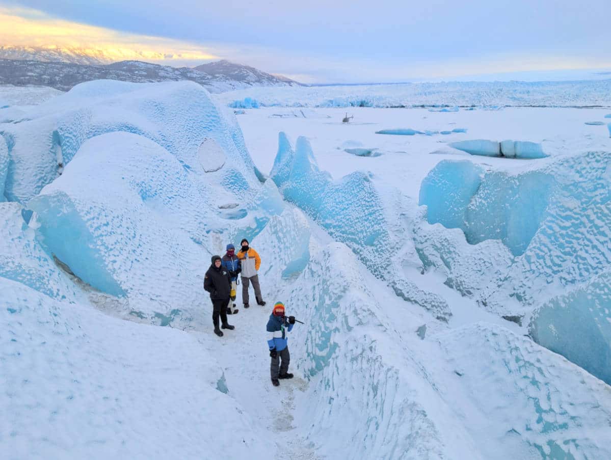 Taylor Family on Frozen Lake at Knik Glacier with Outbound Heli Adventures Helicopter in Palmer Alaska