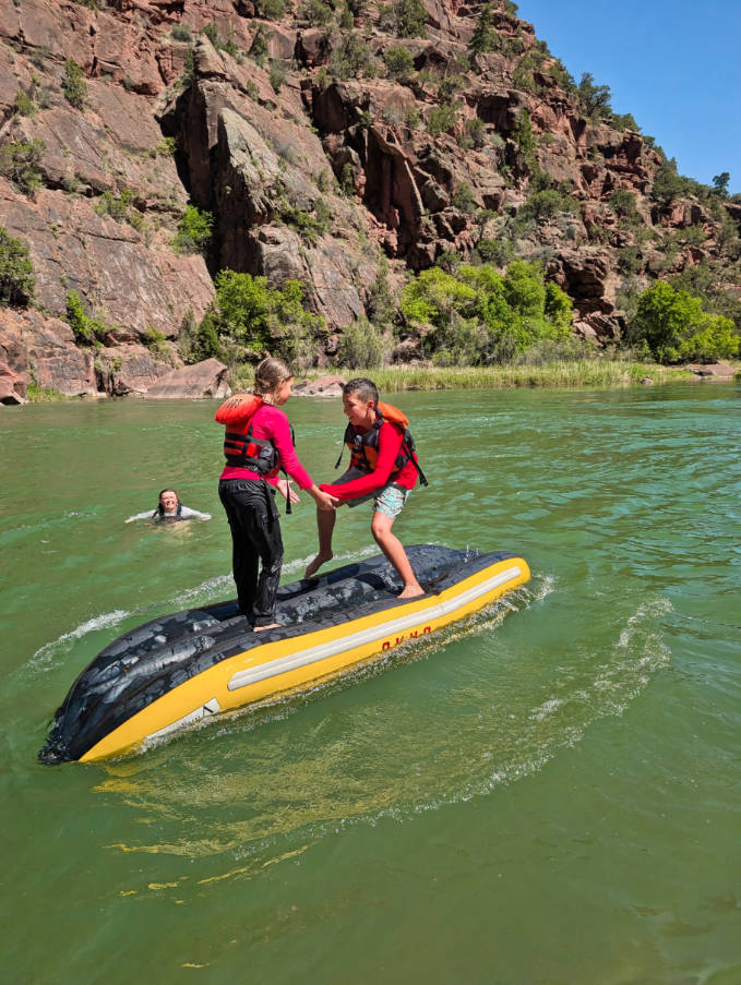 Taylor Family playing on inflafable kayak while Rafting the Green River with OARS in Dinosaur National Monument Gates of Lodore Utah 1